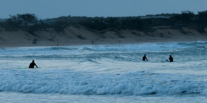 Tre surfisti in riva al mare